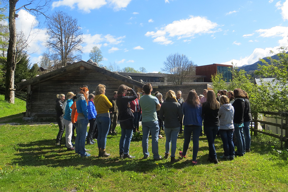 Almhütte im Außengelände des Nationalparkzentrums mit Personen